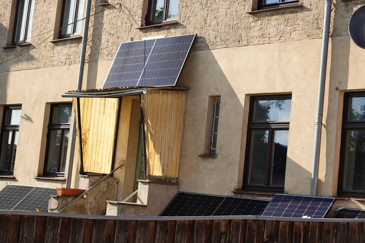 Solarmodule an der Fassade und dem Balkon eines Mehrfamilienhauses