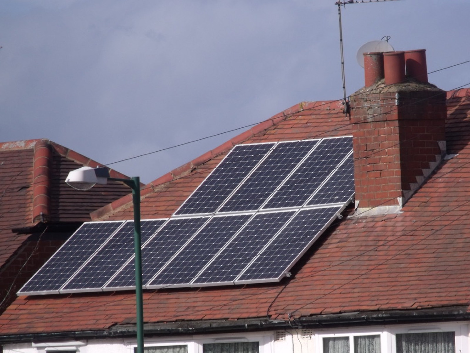 Photovoltaikanlage auf einem roten Ziegeldach eines Wohnhauses